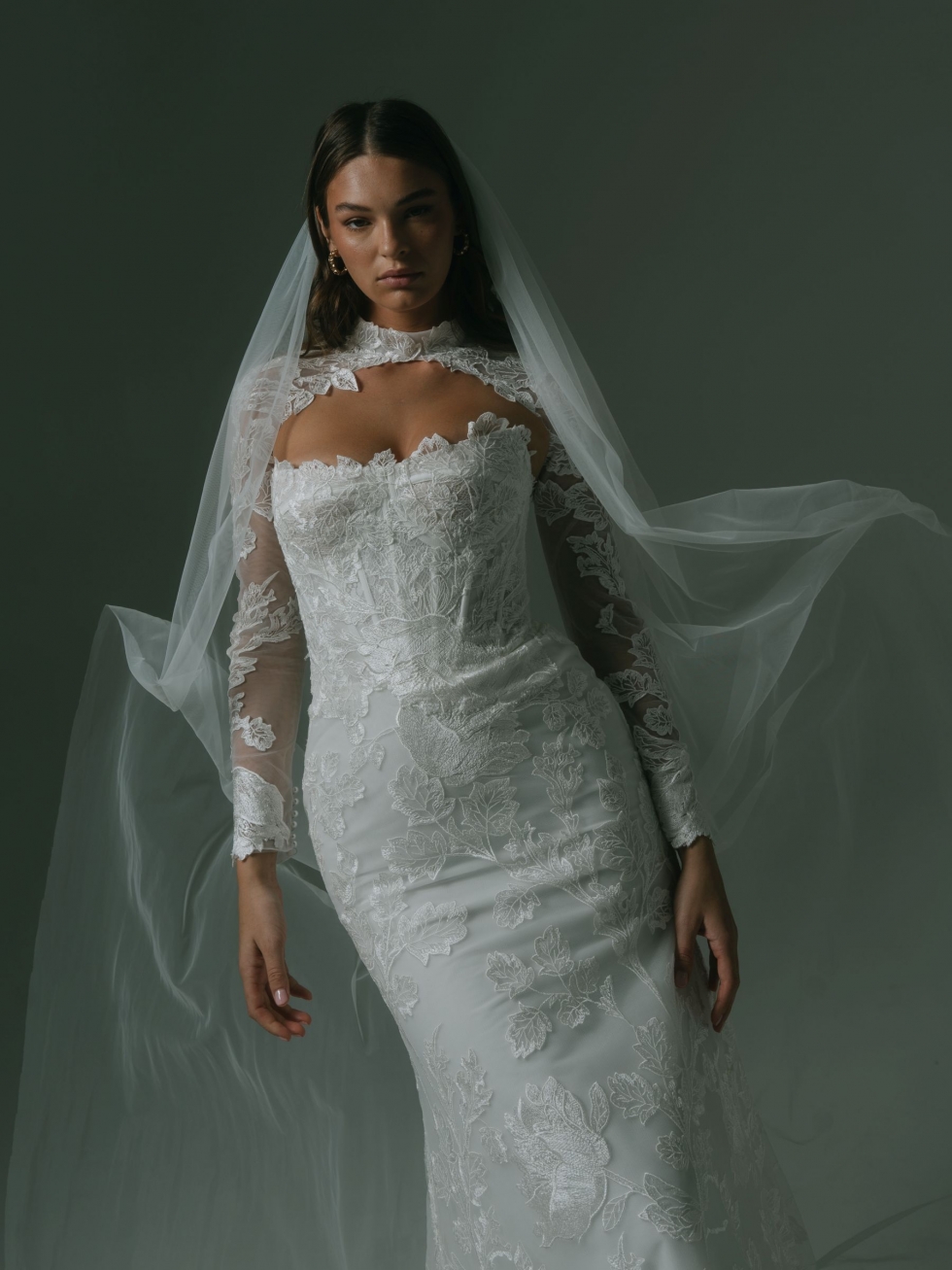 Alec: This figure-hugging gown showcases Guipure lace, a strapless neckline, and a fishtail skirt, with an optional matching high-neck shrug