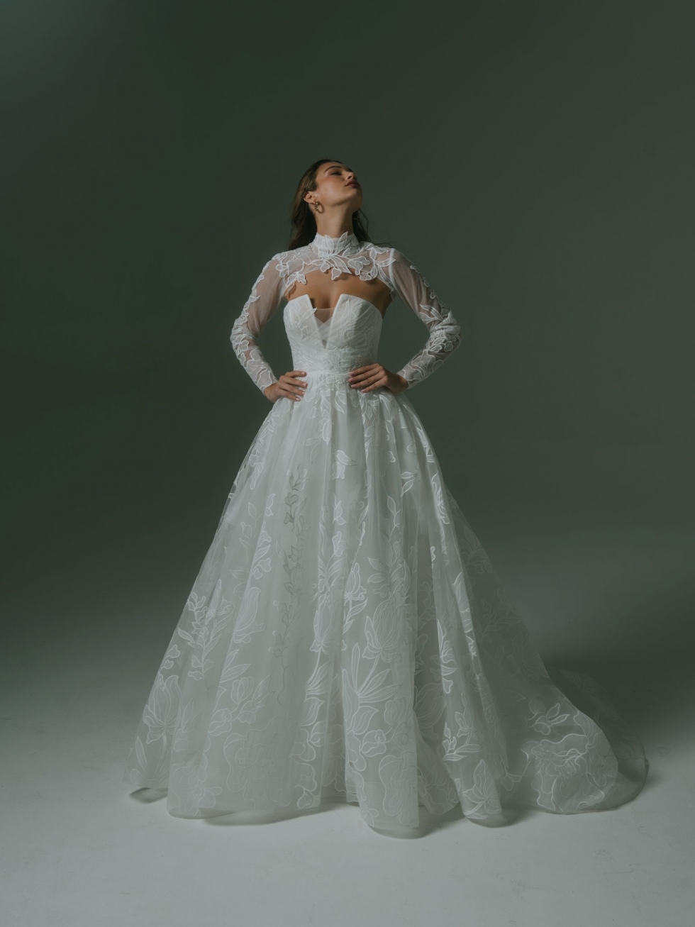 Leona: This gown features a strapless bodice with criss-crossed tulle, a full skirt with tulle and organza, and an optional high-neck shrug