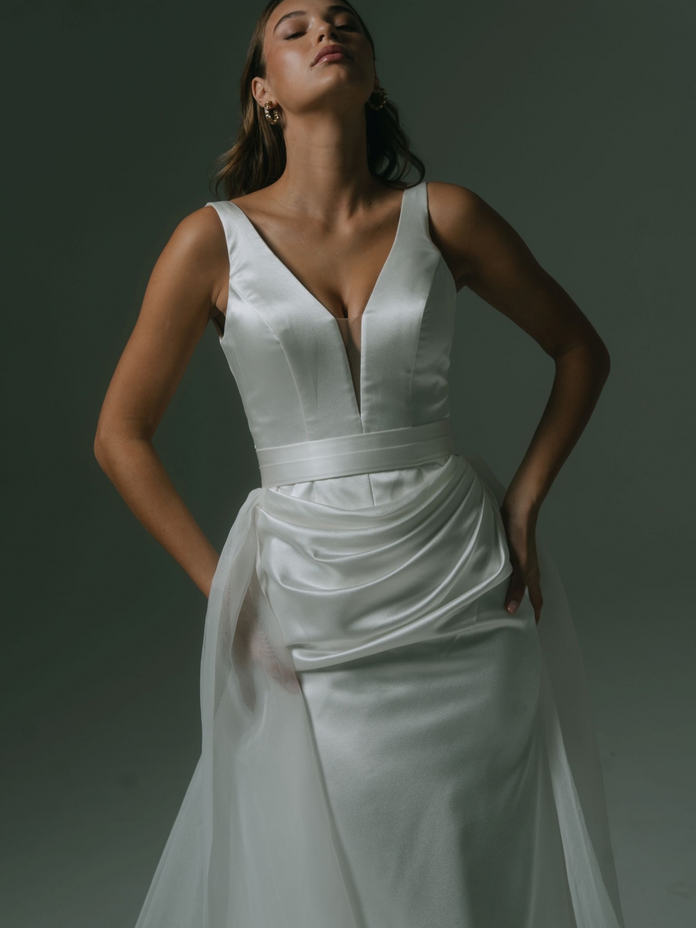 Madame: This sleek silky satin gown features a deep V-neckline, modern pleats, and an optional organza overskirt for added drama