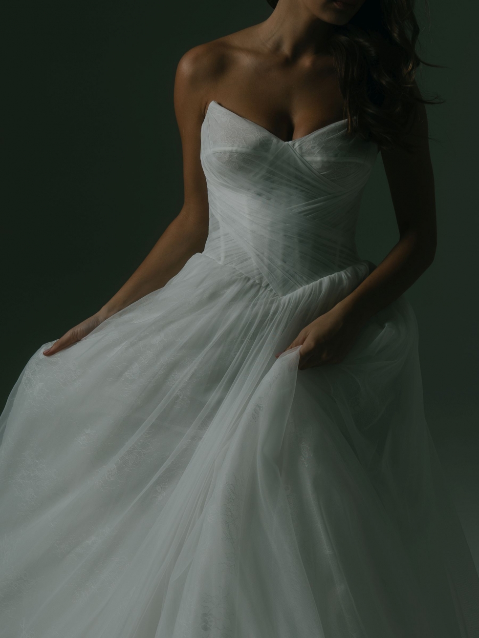 Vienna V3: This romantic gown features hand-crafted pleats, a boned bodice, and Chantilly lace peeking through soft tulle