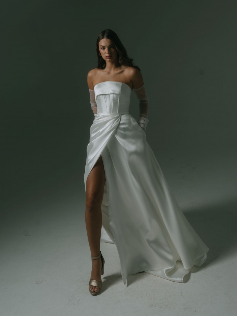 Viktor: A strapless Mikado gown with a corseted bodice, A-line skirt, pockets, and a high split, Viktor offers a classic yet contemporary feel