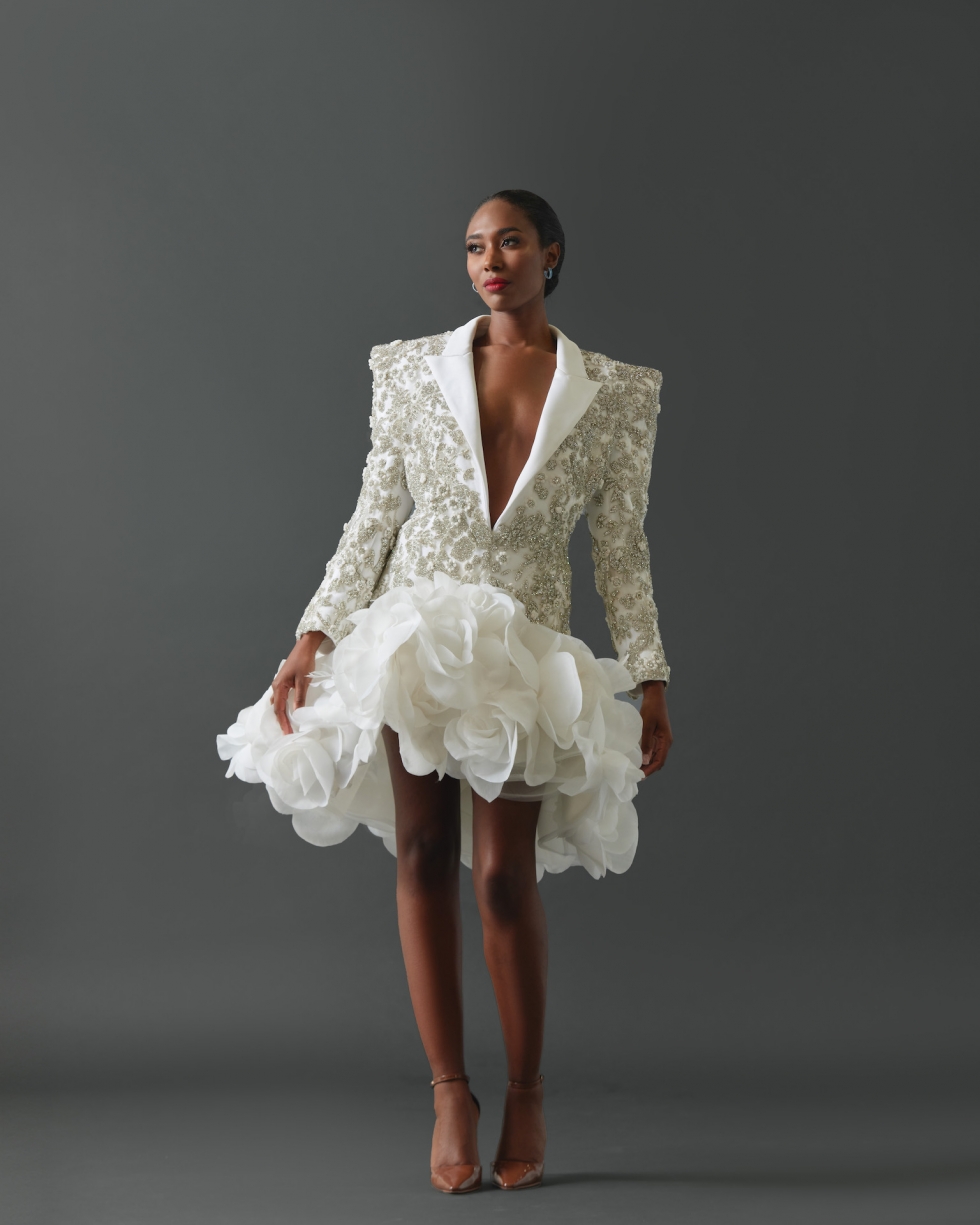 Mini dress comprised of tuxedo jacket with structured shoulders. Entire jacket encrusted with signature crystal and floral applique framed by clean lapel. Skirt of dress featuring large hand-made silk organza rosettes.