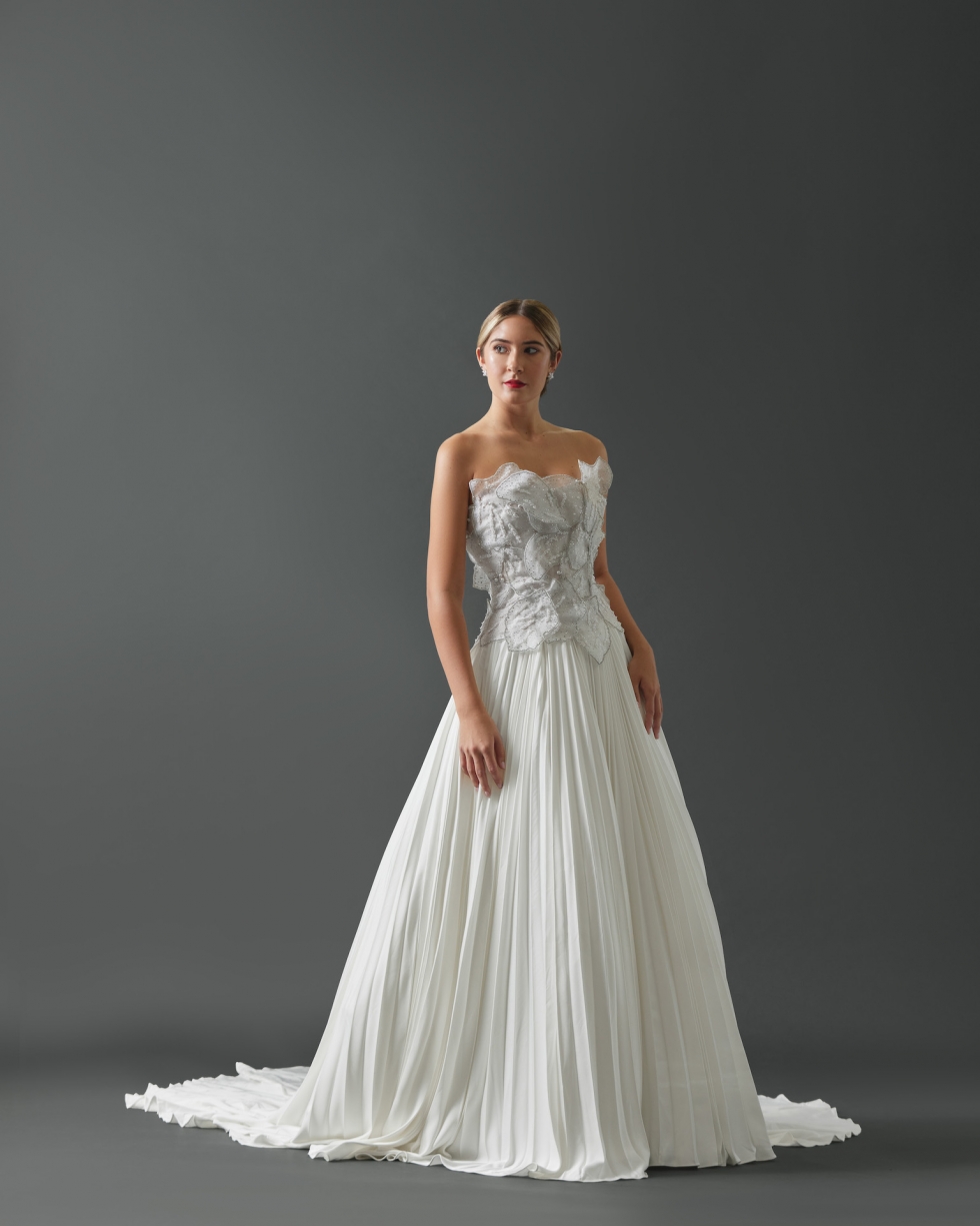 Aline strapless gown featuring layered pearl and crystal encrusted petals on bodice and a pleated skirt.