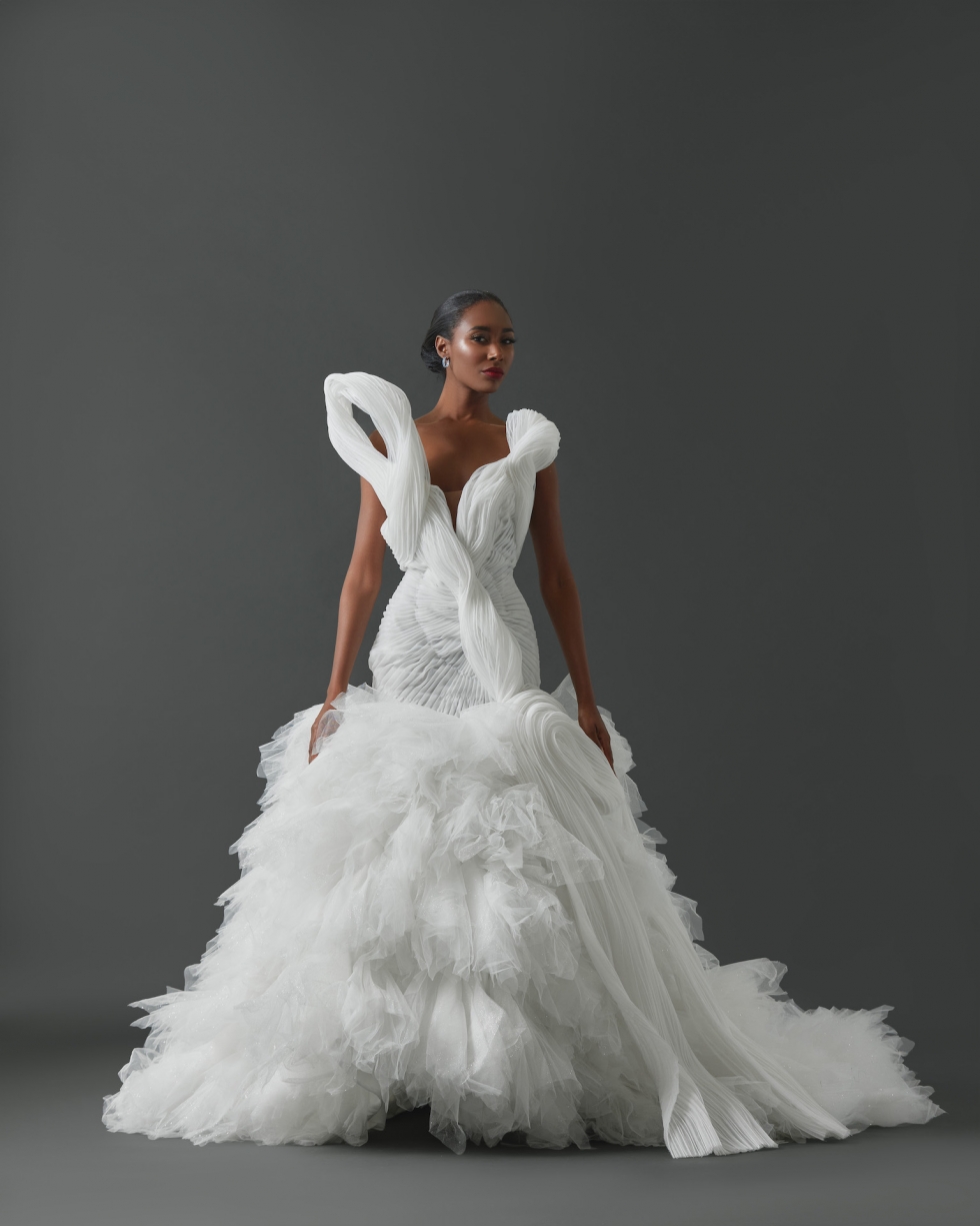 Strapless mermaid gown with structural asymmetrical pleated detail across bodice and pleated tulle framing body. Mermaid skirt constructed with handkerchief cut pieces of tulle.