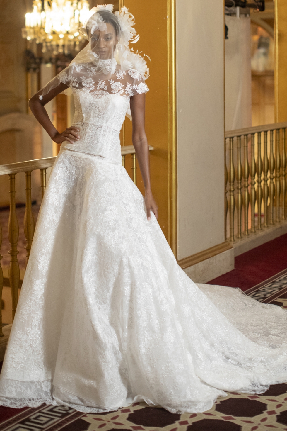 Lace ballgown featuring floral accents and a high neckline.