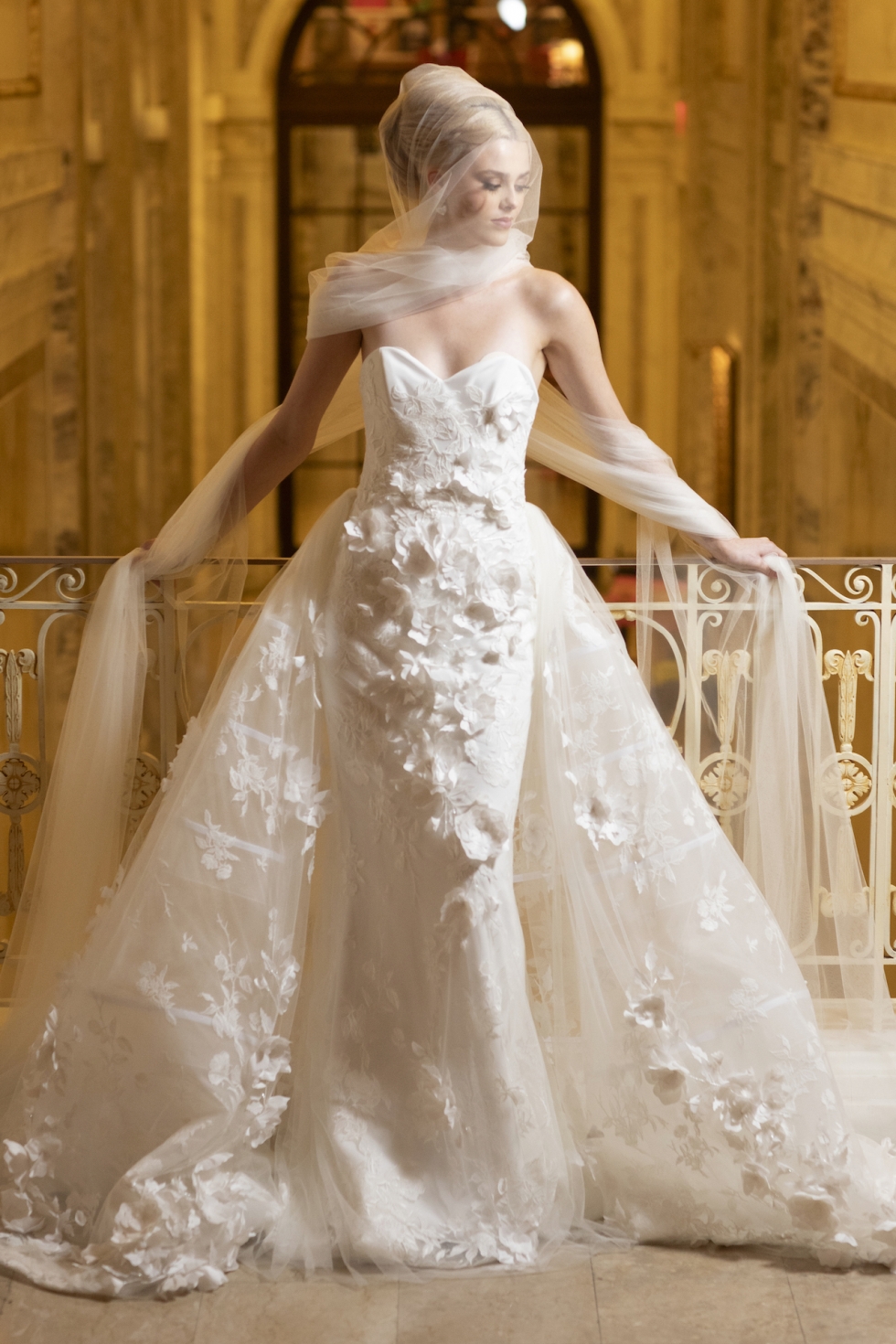 Fitted floral gown with sheer train and delicate veil.